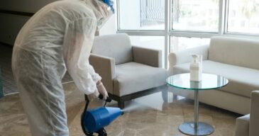 Man in white protective suit in the hotel sprays hotel rooms, elevator to prevent the contamination of corona virus.Ulv Cold Fogger machine